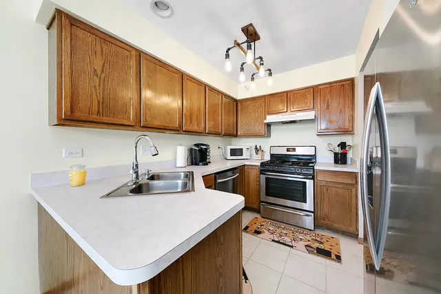a kitchen with a sink stainless steel appliances and white cabinets