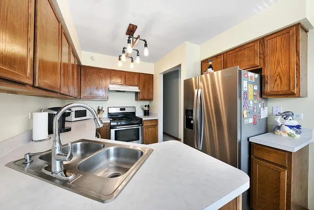 a kitchen with stainless steel appliances granite countertop a sink refrigerator and microwave