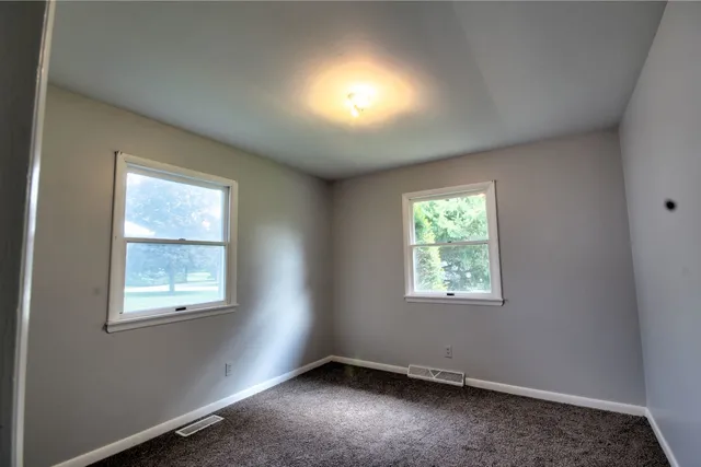 an empty room with windows and closet