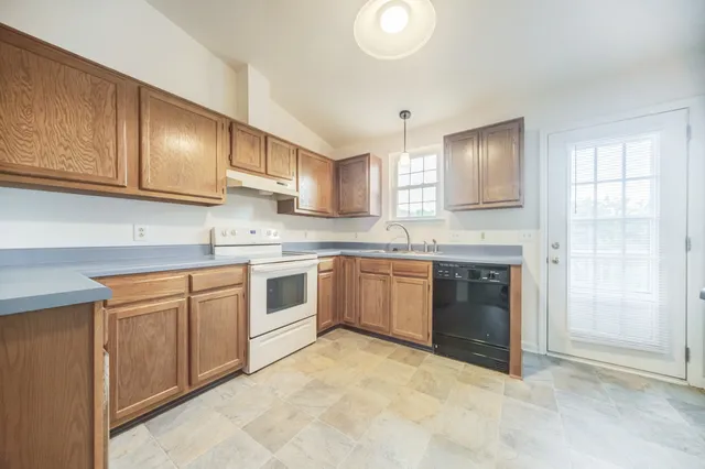 a kitchen with stainless steel appliances granite countertop a stove sink and cabinets