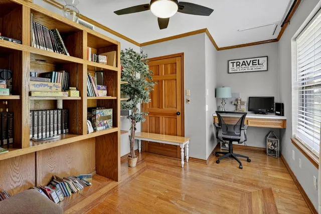 a view of a workspace with furniture and a book shelf
