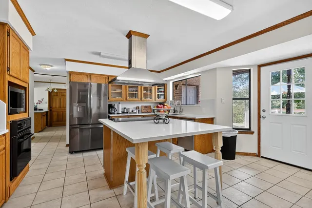 a kitchen with stainless steel appliances granite countertop a sink and a refrigerator
