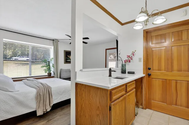 a bedroom with a bed chandelier and a view of living room
