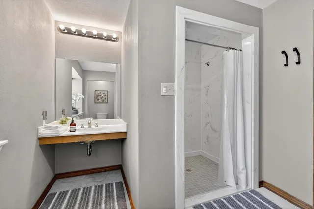 a bedroom with a sink and a large mirror