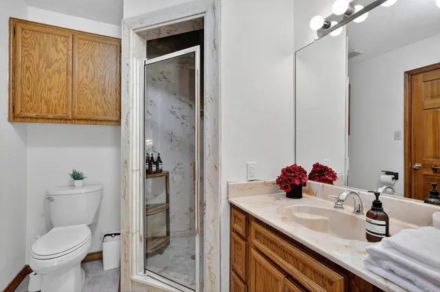 a view of a hallway with bathroom and wooden floor