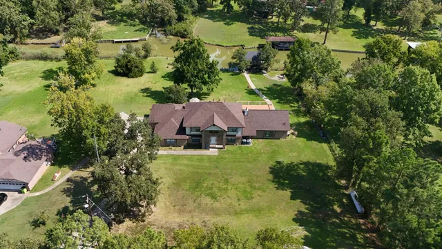 an aerial view of a house with a yard and lake view