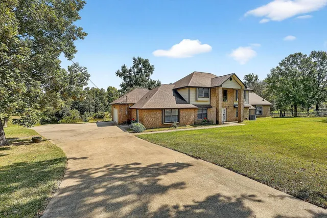 a front view of a house with yard and green space