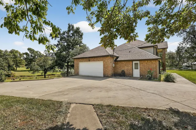 a front view of a house with a garden and tree
