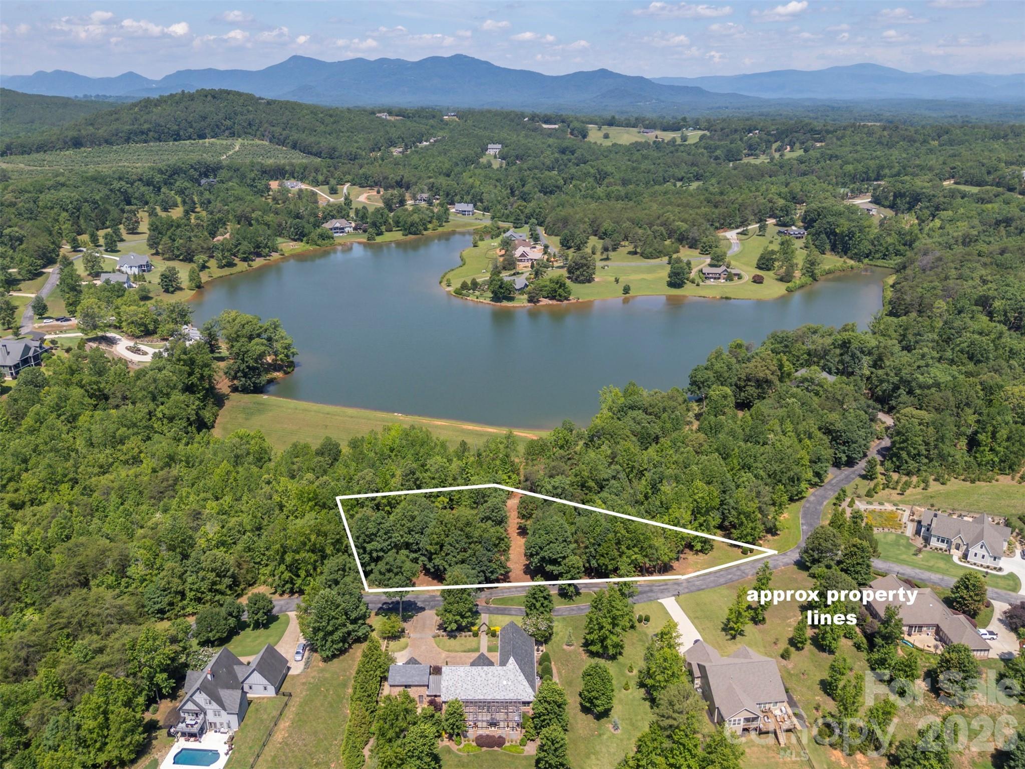0 Doveridge Drive, Unit 66 Tryon, NC 28782 - Photo 1 of 21 an aerial view of lake and residential houses with outdoor space