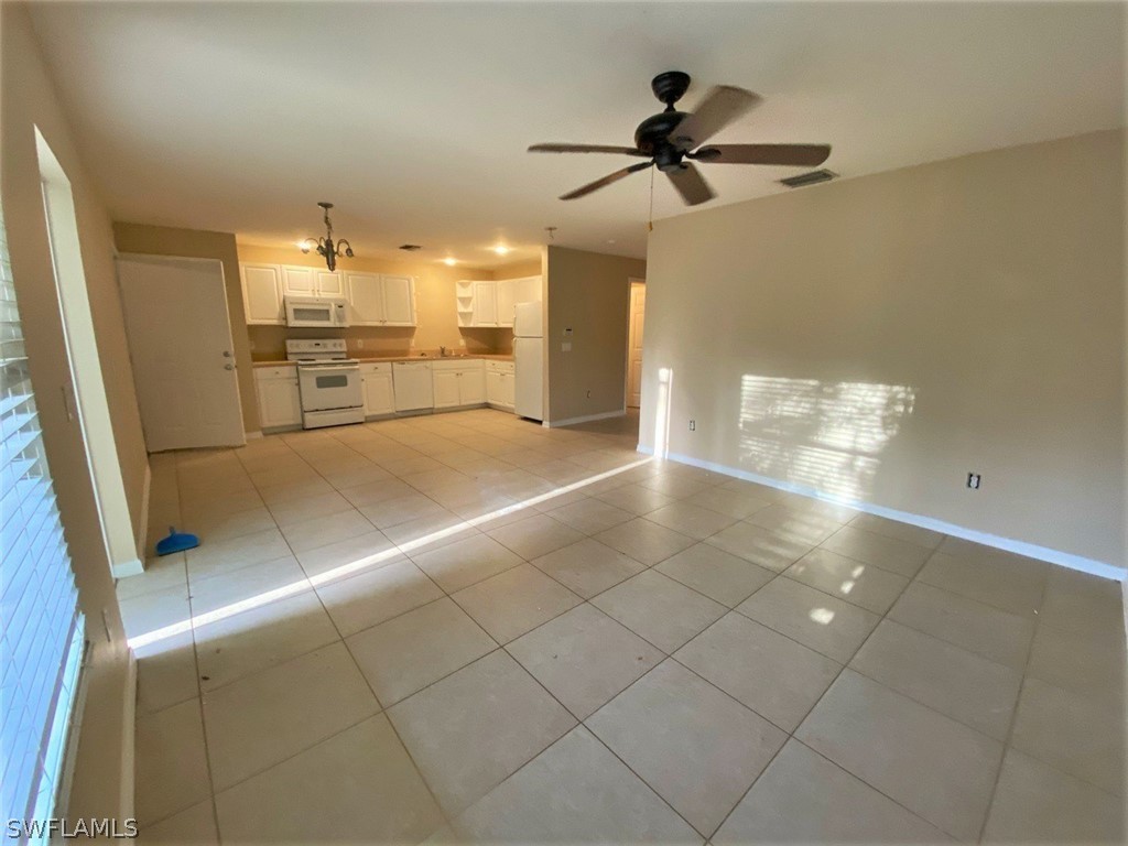 917 Homestead Road South Lehigh Acres, FL 33974 - Photo 3 of 35 a view of a kitchen with a sink and a refrigerator