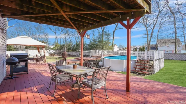 a patio with wooden floor a yard a table and chairs