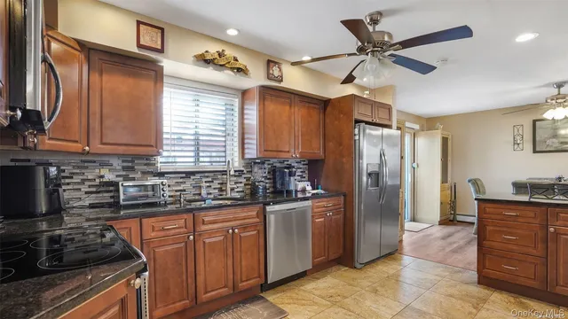 a kitchen with stainless steel appliances granite countertop a stove a refrigerator and a sink