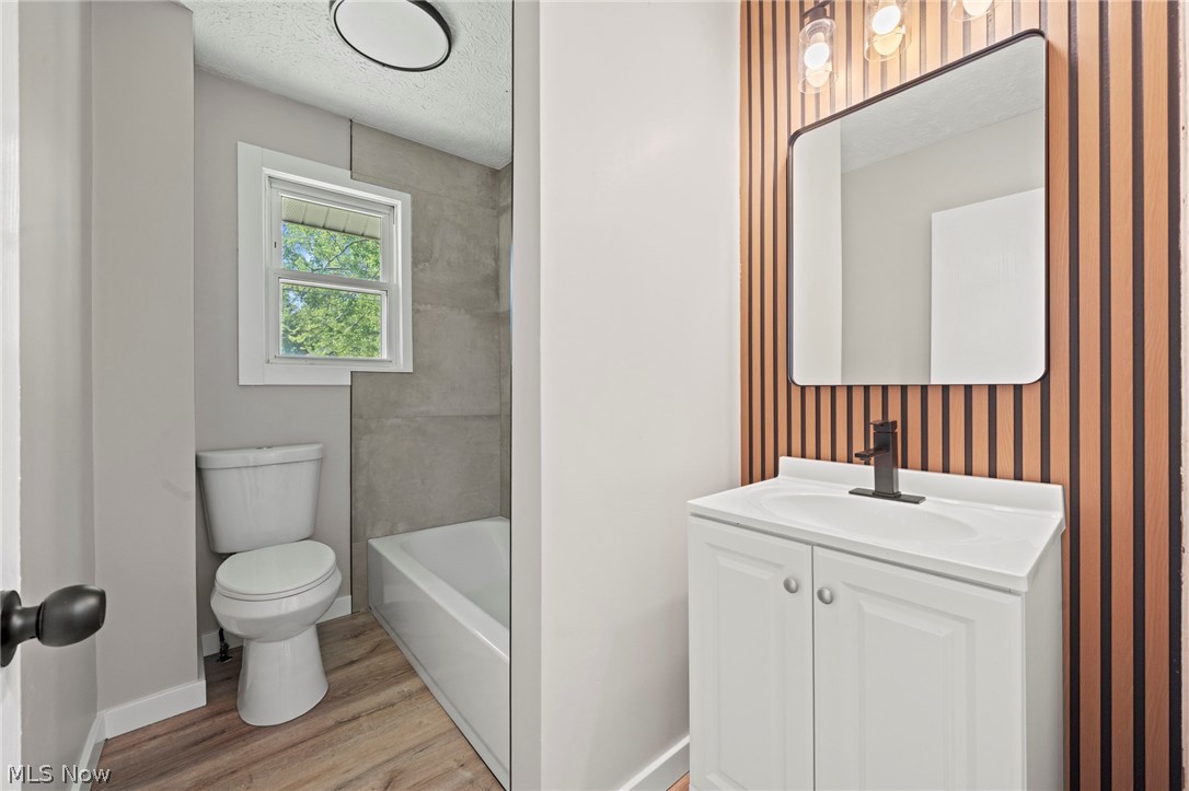 1218 Briggle Road Akron, OH 44320 - Photo 20 of 40 Bathroom featuring a white vanity with integrated sink, matte black faucet, and a wall-mounted mirror
