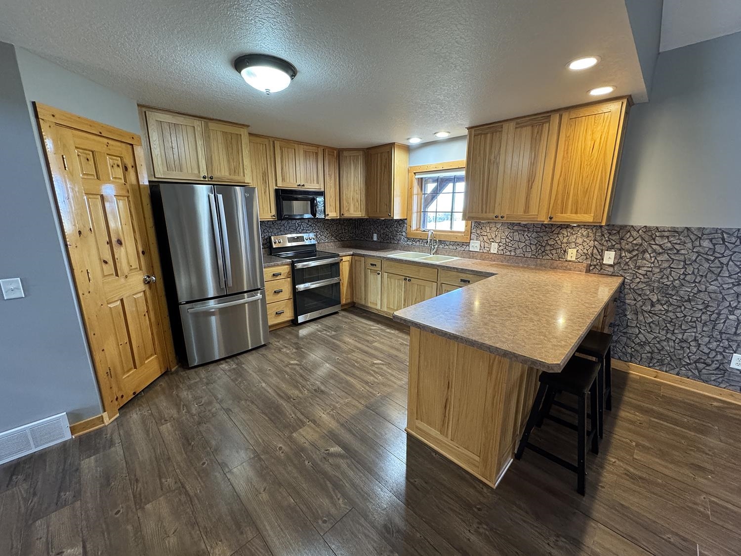 7876 Hickory Grove Road Savanna, IL 61074 - Photo 16 of 67 a kitchen with stainless steel appliances granite countertop a refrigerator a sink dishwasher a stove with wooden floors