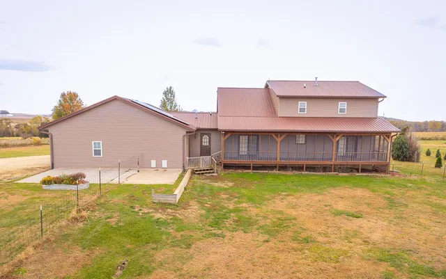 a view of a house with backyard and sitting area