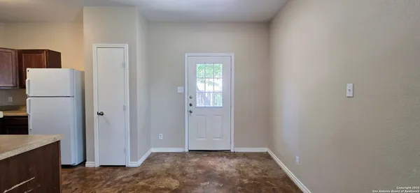 a view of hallway with a refrigerator and microwave