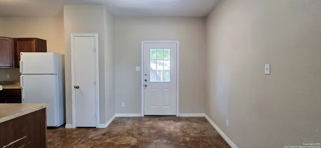 a view of hallway with a refrigerator and microwave