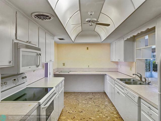 a kitchen with stainless steel appliances kitchen island granite countertop a sink stove and cabinets