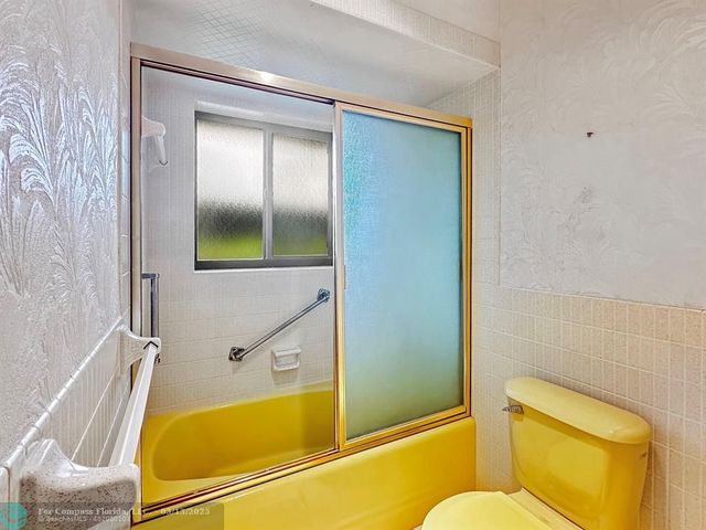 a living room with furniture a chandelier and a flat screen tv