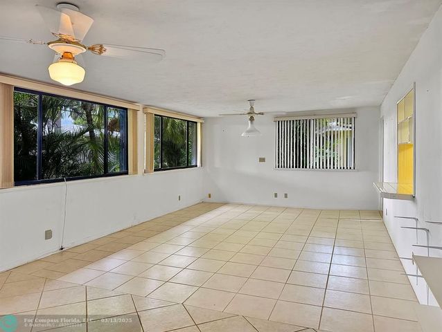 a living room with furniture kitchen view and a wooden floor