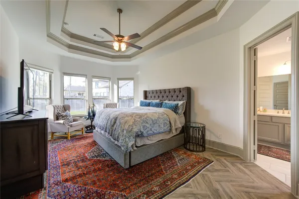 a spacious bedroom with a bed a chandelier and large window