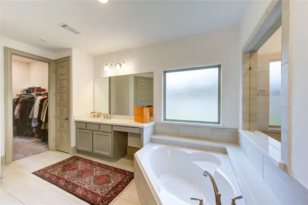 a bathroom with a tub sink and mirror