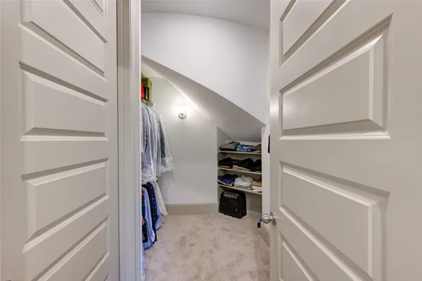 a view of walk in closet with clothes and shoes