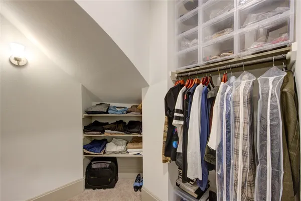 a view of walk in closet with clothes and shoes