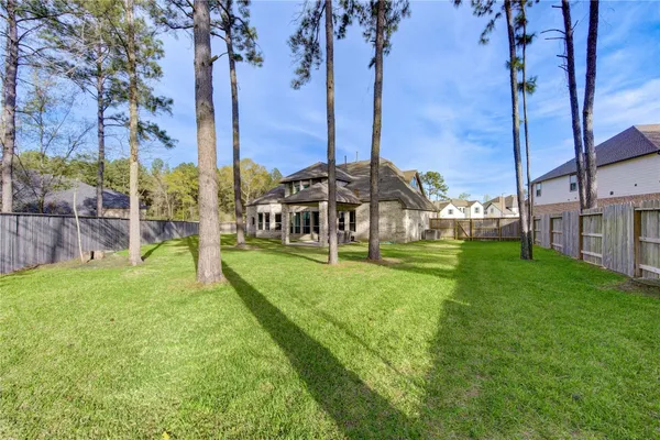 a view of a house with backyard and a tree