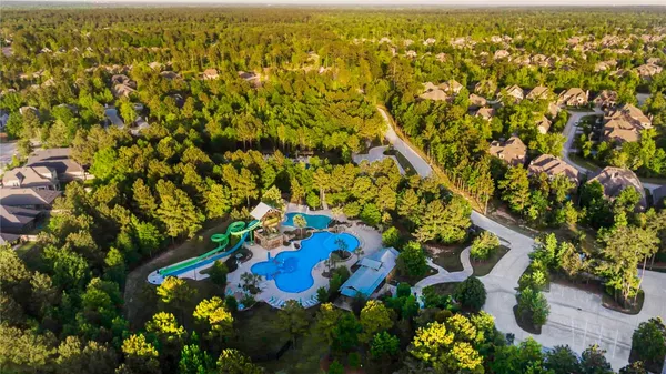 an aerial view of residential houses with outdoor space and trees