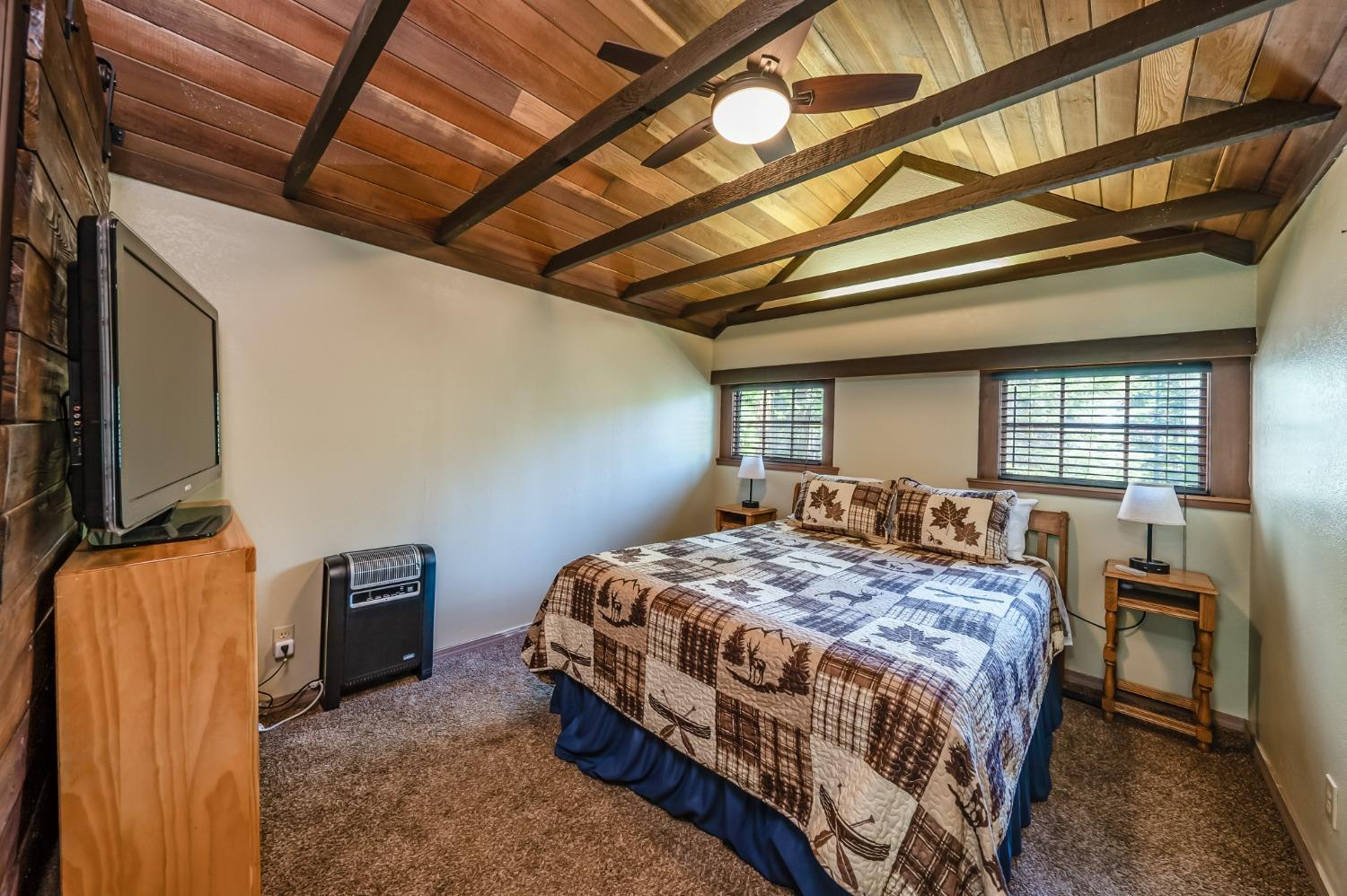 41534 Indian Rock Road Shaver Lake, CA 93664 - Photo 16 of 19 a bedroom with a bed next to a window with tv