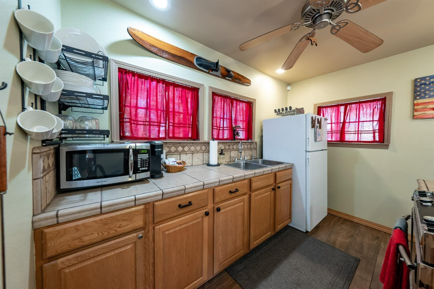 41534 Indian Rock Road Shaver Lake, CA 93664 - Photo 10 of 19 a kitchen with stainless steel appliances kitchen island granite countertop a stove a sink dishwasher and a microwave
