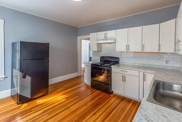 a kitchen with granite countertop a refrigerator stove and sink