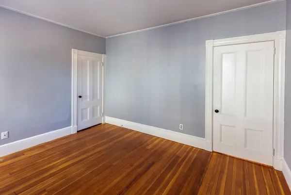 a view of an empty room with wooden floor