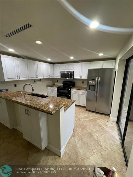 a kitchen with stainless steel appliances granite countertop a sink stove and a refrigerator