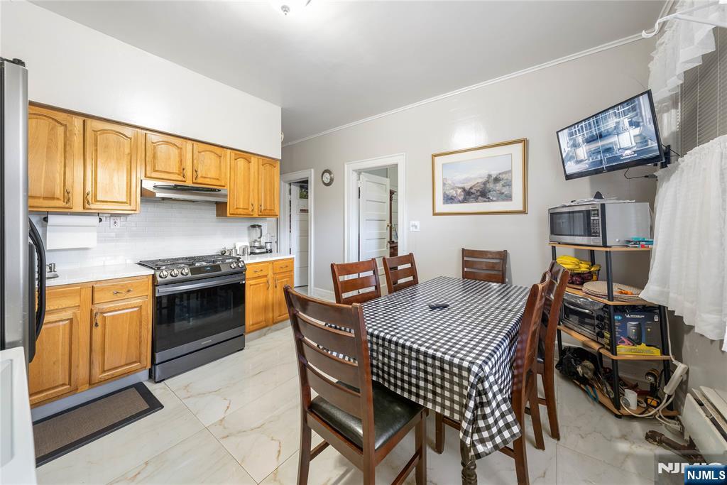 58 Park Paterson, NJ 07501 - Photo 10 of 36 a open kitchen with stainless steel appliances granite countertop a stove top oven a sink a dining table and chairs with wooden floor