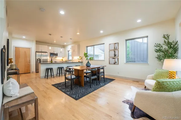 a living room with furniture and a dining table with kitchen view