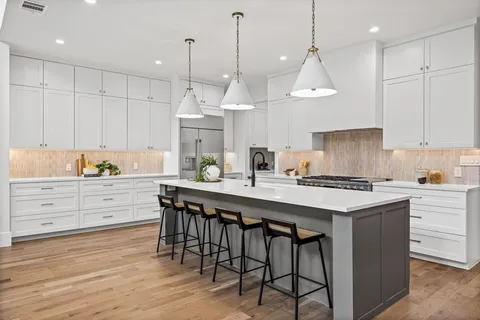 a kitchen with kitchen island granite countertop a sink a center island and cabinets