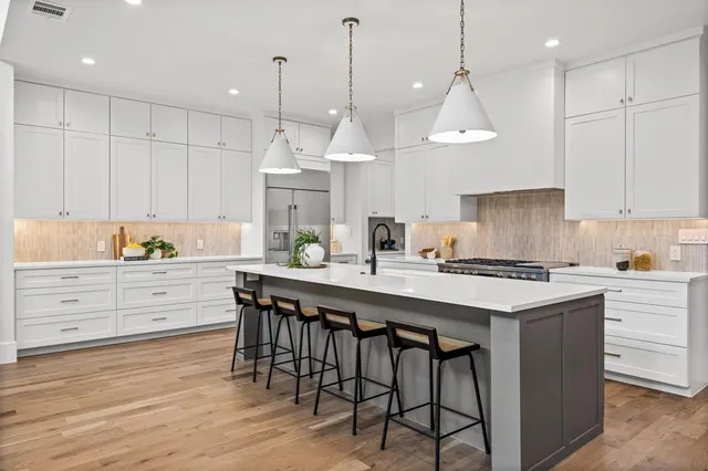 a kitchen with kitchen island granite countertop a sink a center island and cabinets