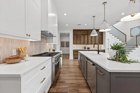 a kitchen with stainless steel appliances granite countertop a lot of counter space and wooden floors