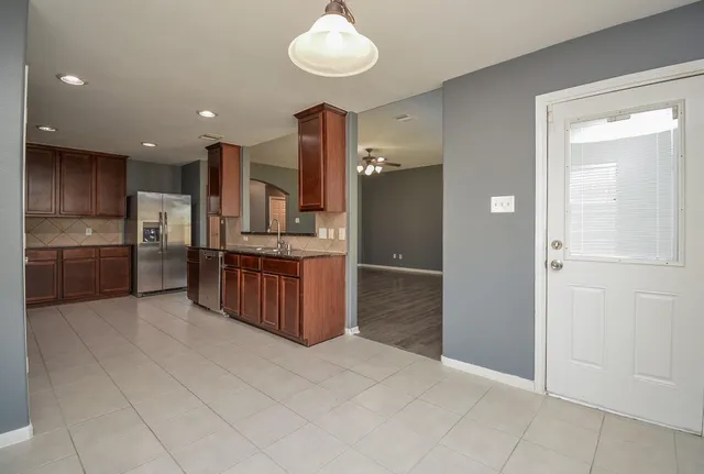 a kitchen with stainless steel appliances granite countertop a refrigerator and a sink