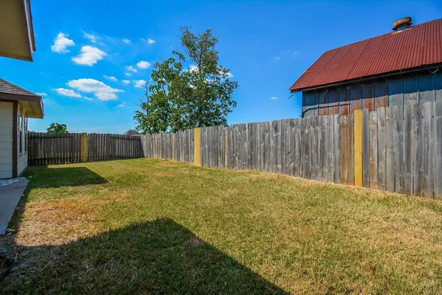a view of backyard with wooden fence