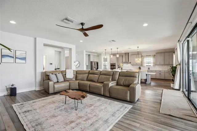 a living room with furniture and a flat screen tv with kitchen view
