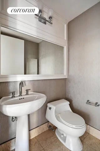 a bathroom with a toilet sink and mirror