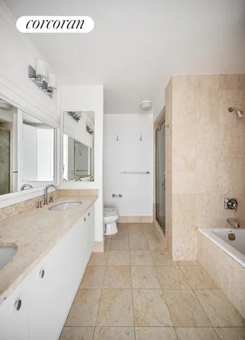 a bathroom with a granite countertop sink a mirror and a bathtub