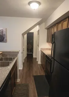 a kitchen with granite countertop a sink stove and refrigerator