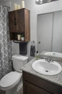 a bathroom with a granite countertop toilet sink and mirror