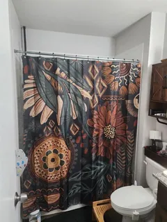 a bathroom with a toilet and a shower curtain