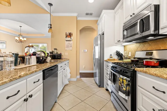 a kitchen with stainless steel appliances granite countertop a stove a sink and a refrigerator