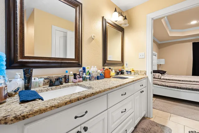 a bathroom with a granite countertop double vanity sink and a mirror